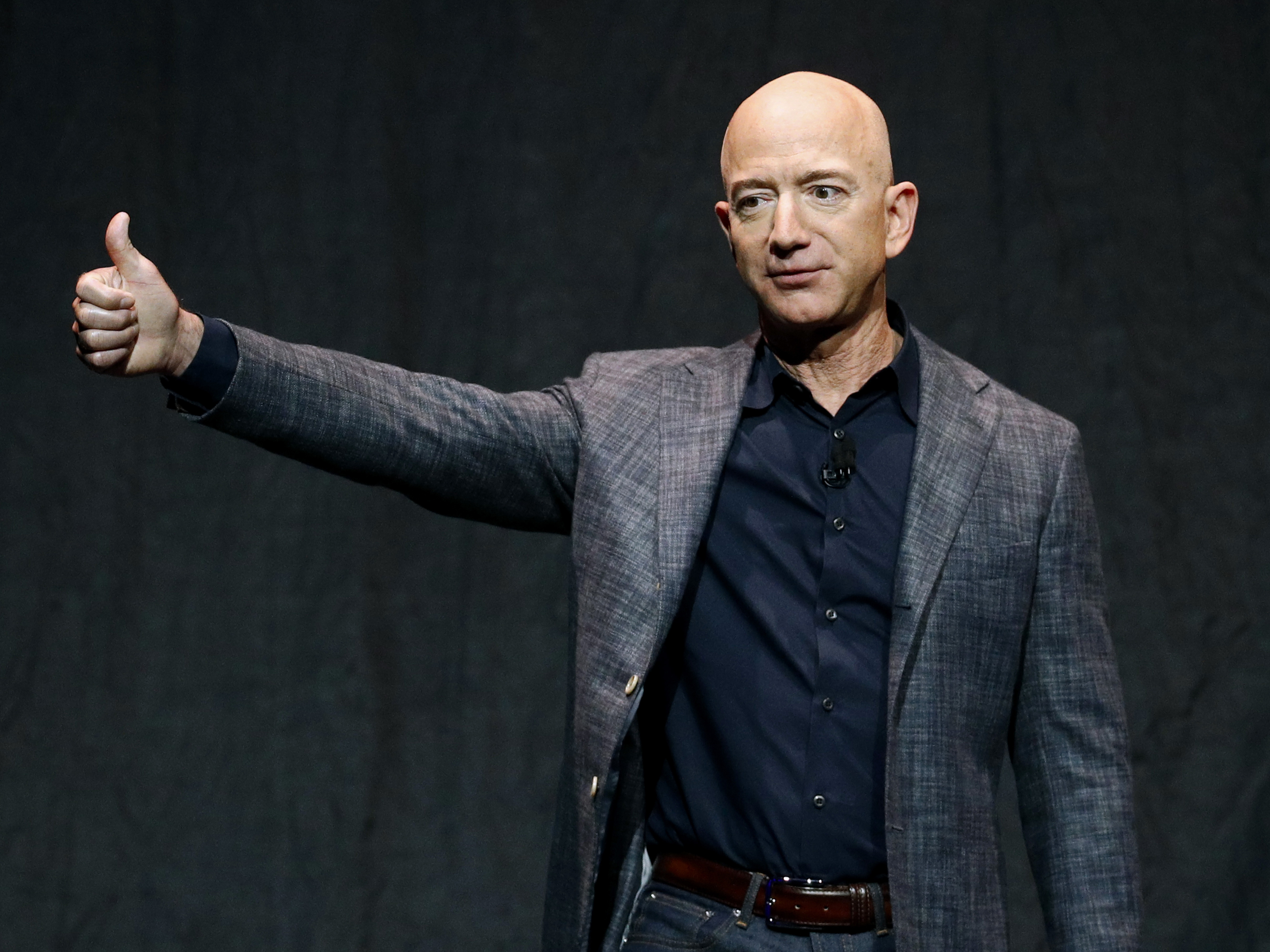 caption: Jeff Bezos will join his brother Mark, one paying auction winner and another unnamed person on the Blue Origin rocket bound for space in July.