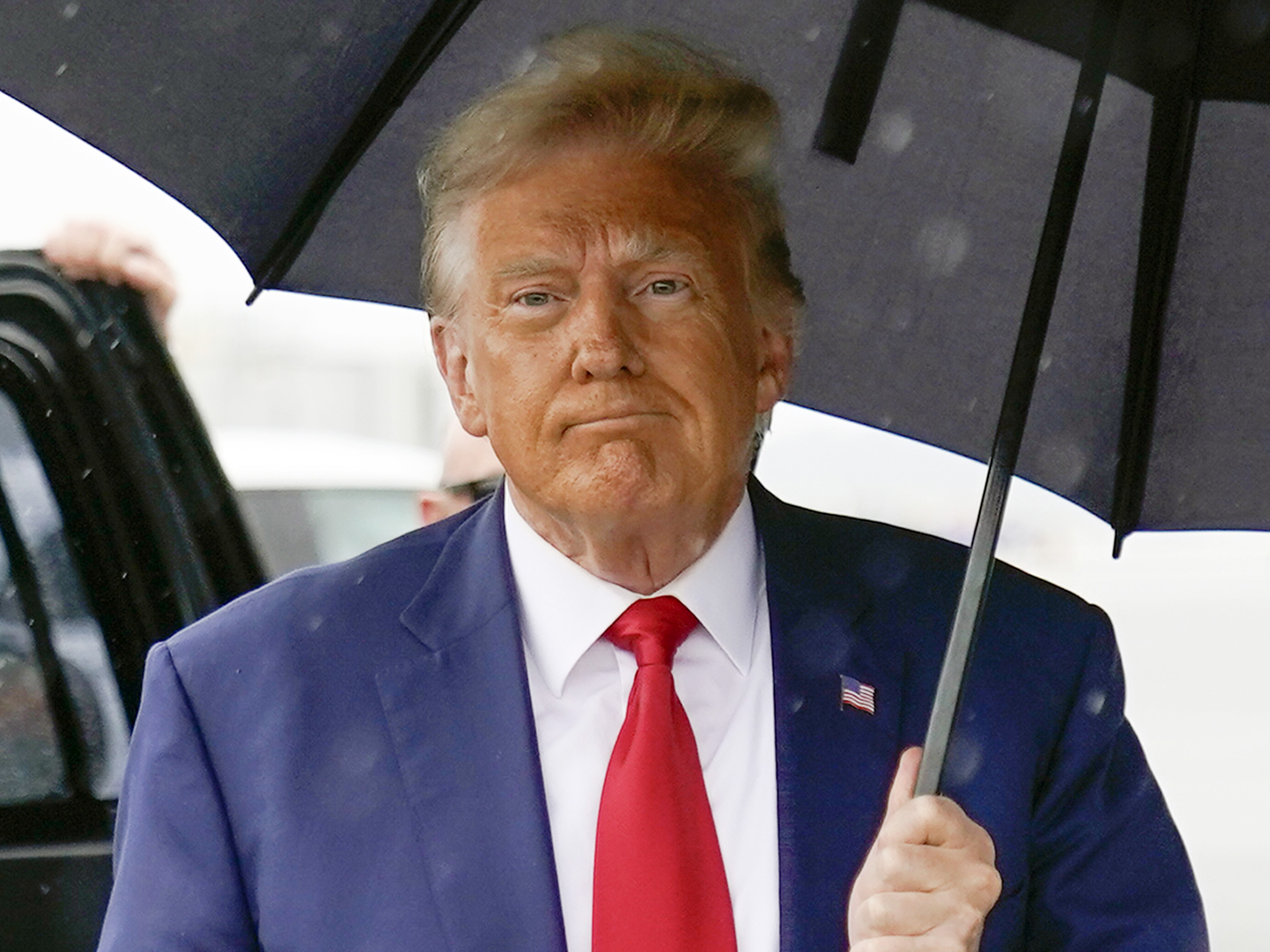 caption: Former President Donald Trump walks to speak with reporters before boarding his plane at Ronald Reagan Washington National Airport on Aug. 3 in Arlington, Va.