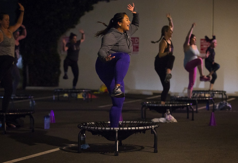 caption: Anna-Marie Lim, center, participates in an outdoor socially-distanced bounce and sculpt fitness class led by Allison Axdorff, not pictured, on Tuesday, October 13, 2020, at Upbeats fitness studio along NW Leary Way in Seattle. 