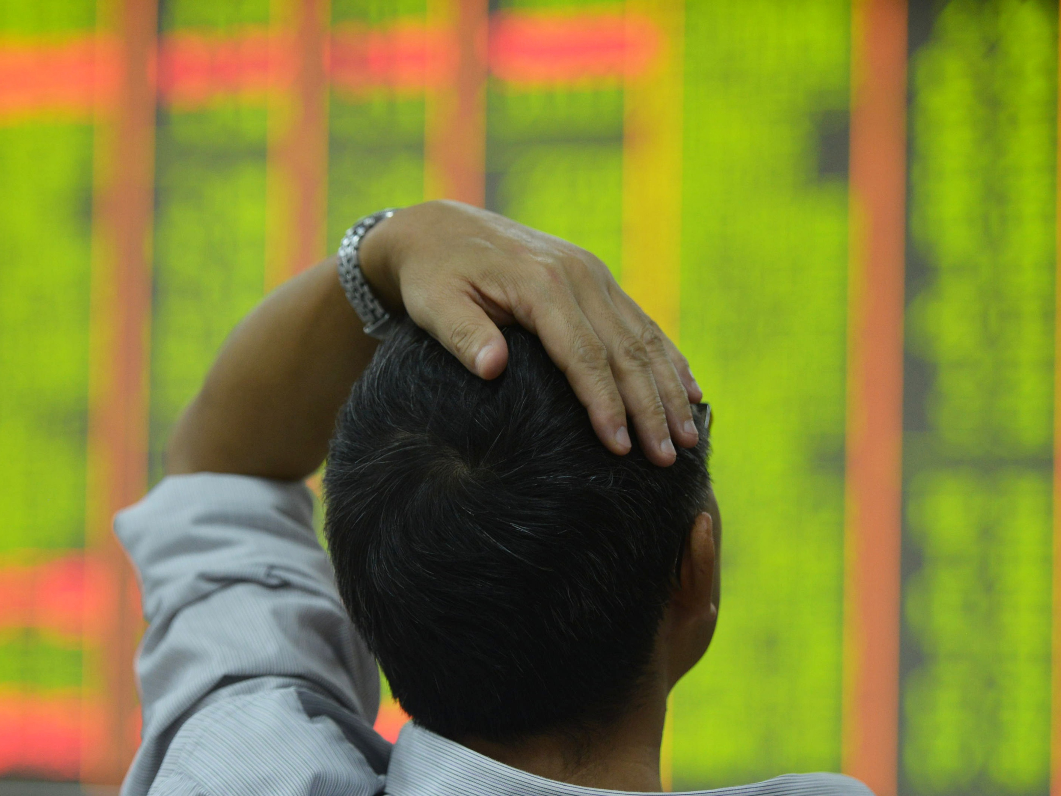 caption: An investor monitors share prices at a securities trading office on Monday in Hangzhou, China.<br><br>