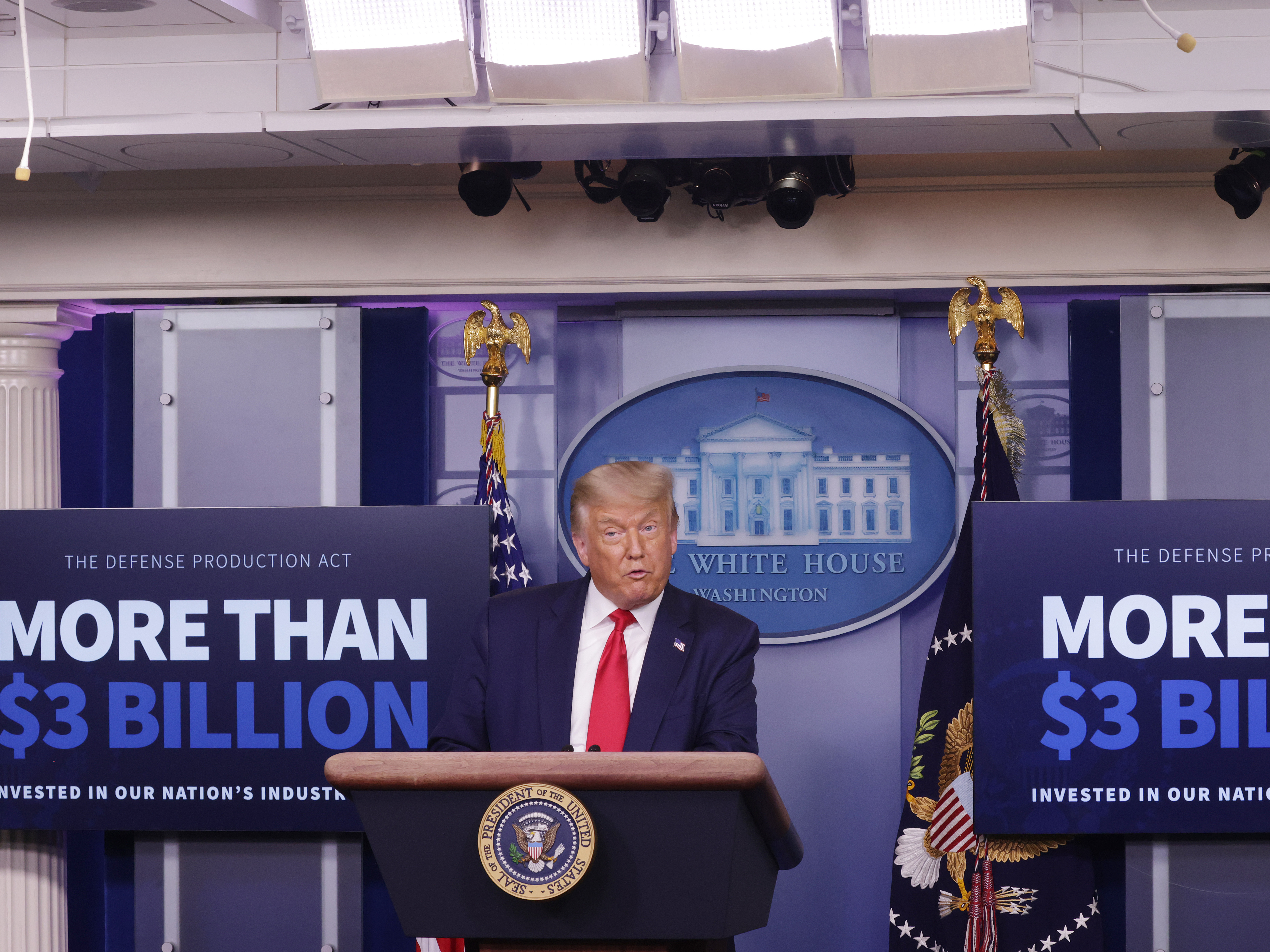 caption: President Trump announces on July 28 that Eastman Kodak will receive a loan to manufacture ingredients used in pharmaceuticals.