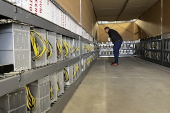 caption: Malachi Salcido, of Salcido Enterprises, looks over his cryptocurrency servers at the Pangborn Data Center in Wenatchee. 