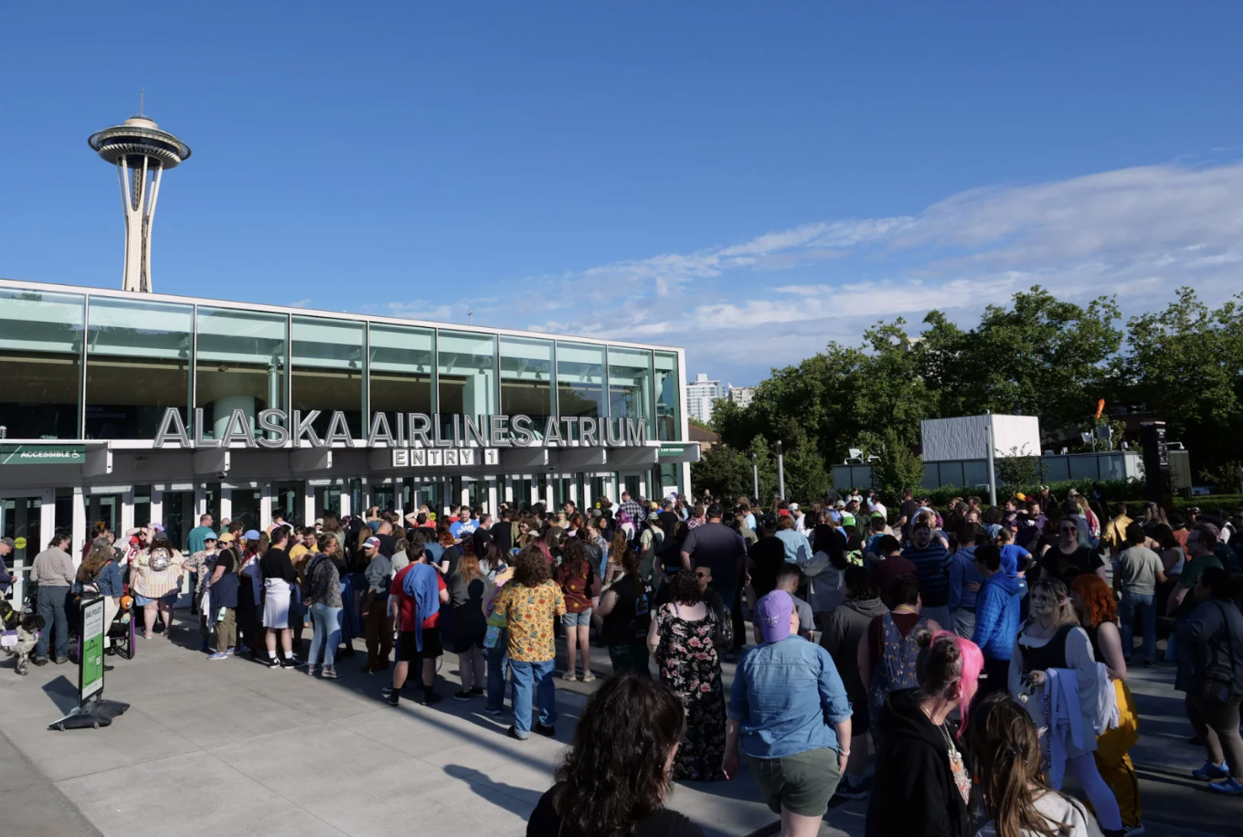 caption: Hundreds of fans line up outside Seattle's Climate Pledge Arena to watch Dimension 20's live show in July of 2025.