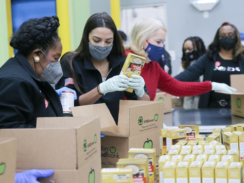 caption: Reps. Sheila Jackson Lee (from left), Alexandria Ocasio-Cortez and Sylvia Garcia help distribute food at the Houston Food Bank on Saturday.