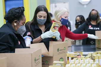 caption: Reps. Sheila Jackson Lee (from left), Alexandria Ocasio-Cortez and Sylvia Garcia help distribute food at the Houston Food Bank on Saturday.