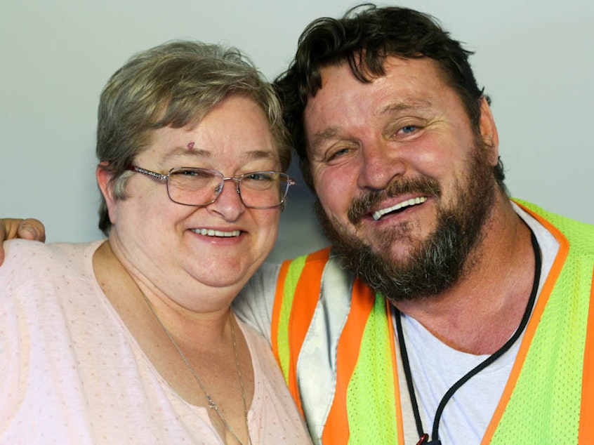 caption: Brian McConnell, right, spoke with his wife, Nora, during a StoryCorps interview in Atlanta in 2016, about his "calling": working with the Delta Honor Guard to greet the remains of a military service members killed in active duty.