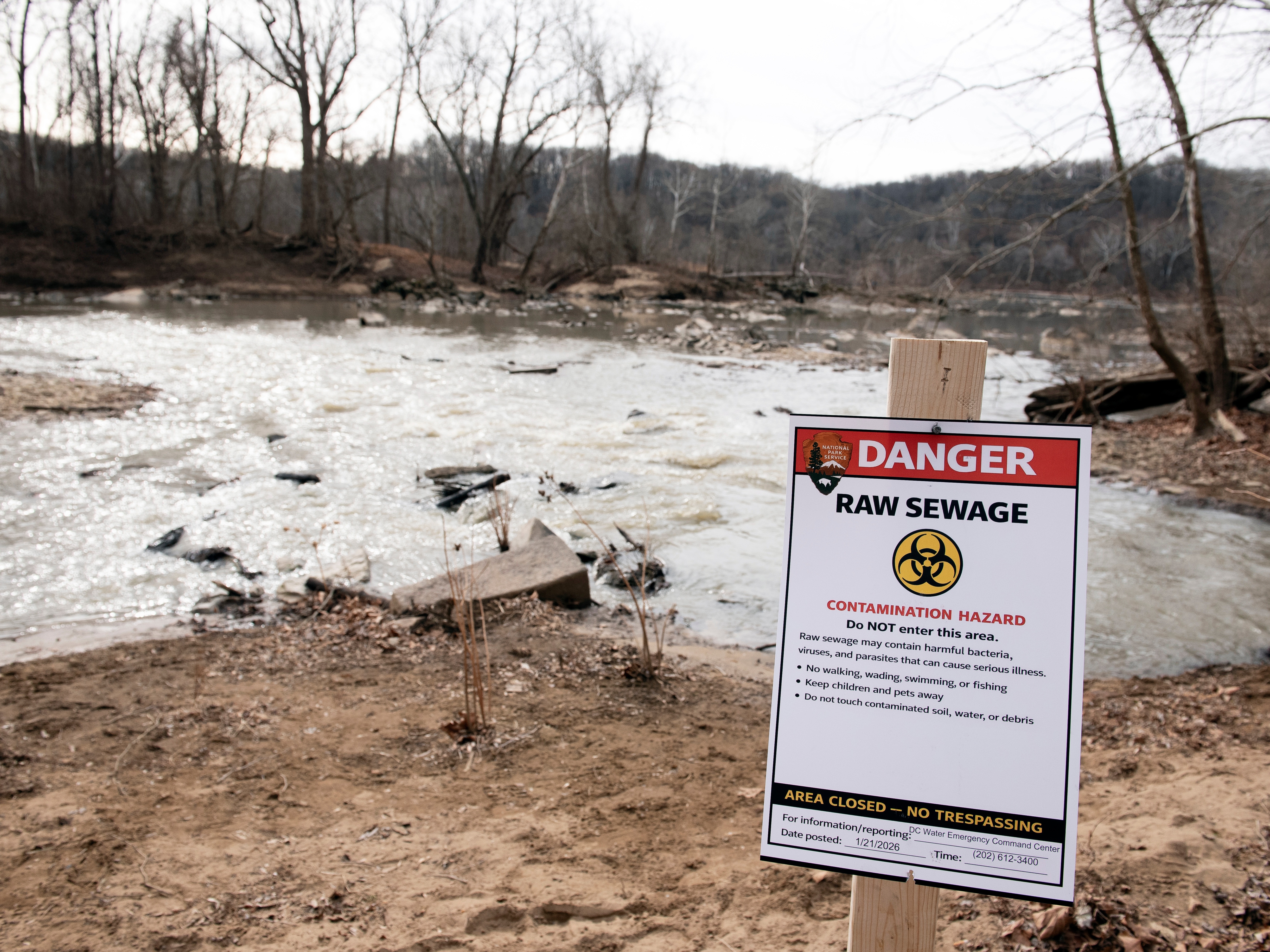 caption: A warning sign was placed in January at the site of a massive pipe rupture, as sewage flowed into the Potomac River in Glen Echo, Md.