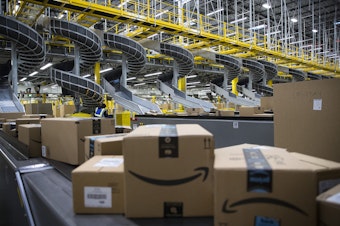caption: Boxed items are shown on conveyer belts leading to docks where they will be loaded onto trucks at an Amazon fulfillment center on Friday, November 3, 2017, in Kent. 