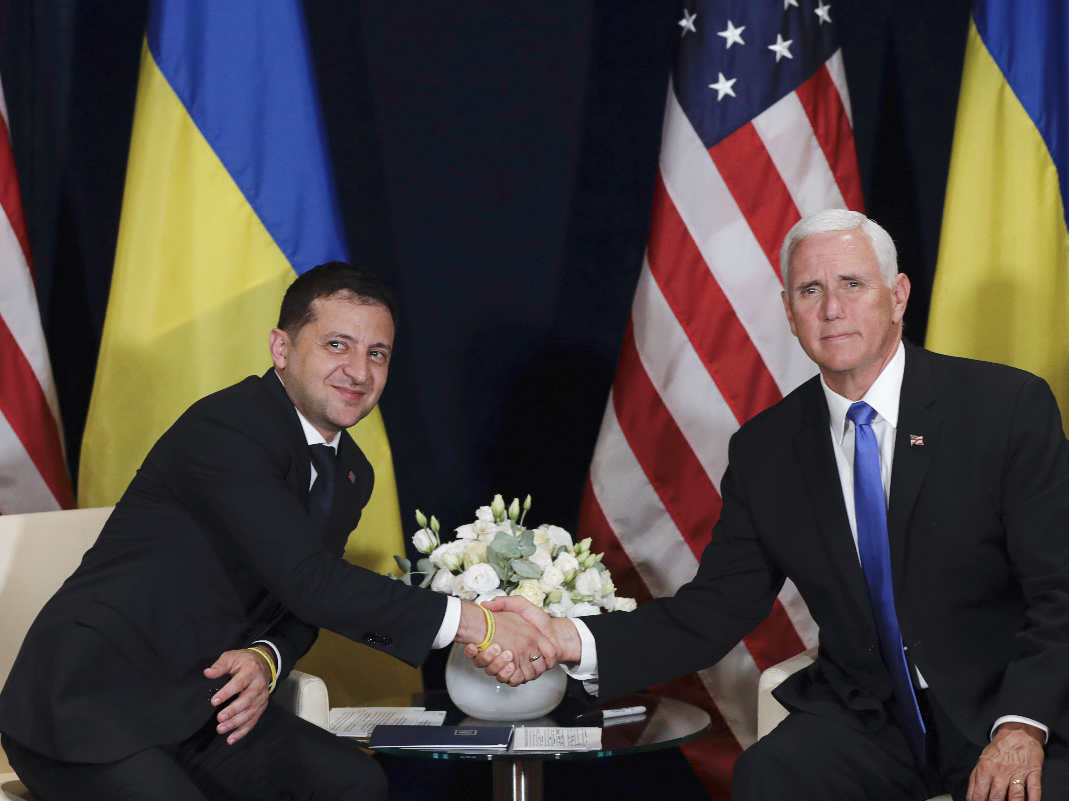 caption: Ukrainian President Volodymyr Zelenskiy shakes hands with Vice President Mike Pence, in Warsaw, Poland on Sept. 1, 2019.