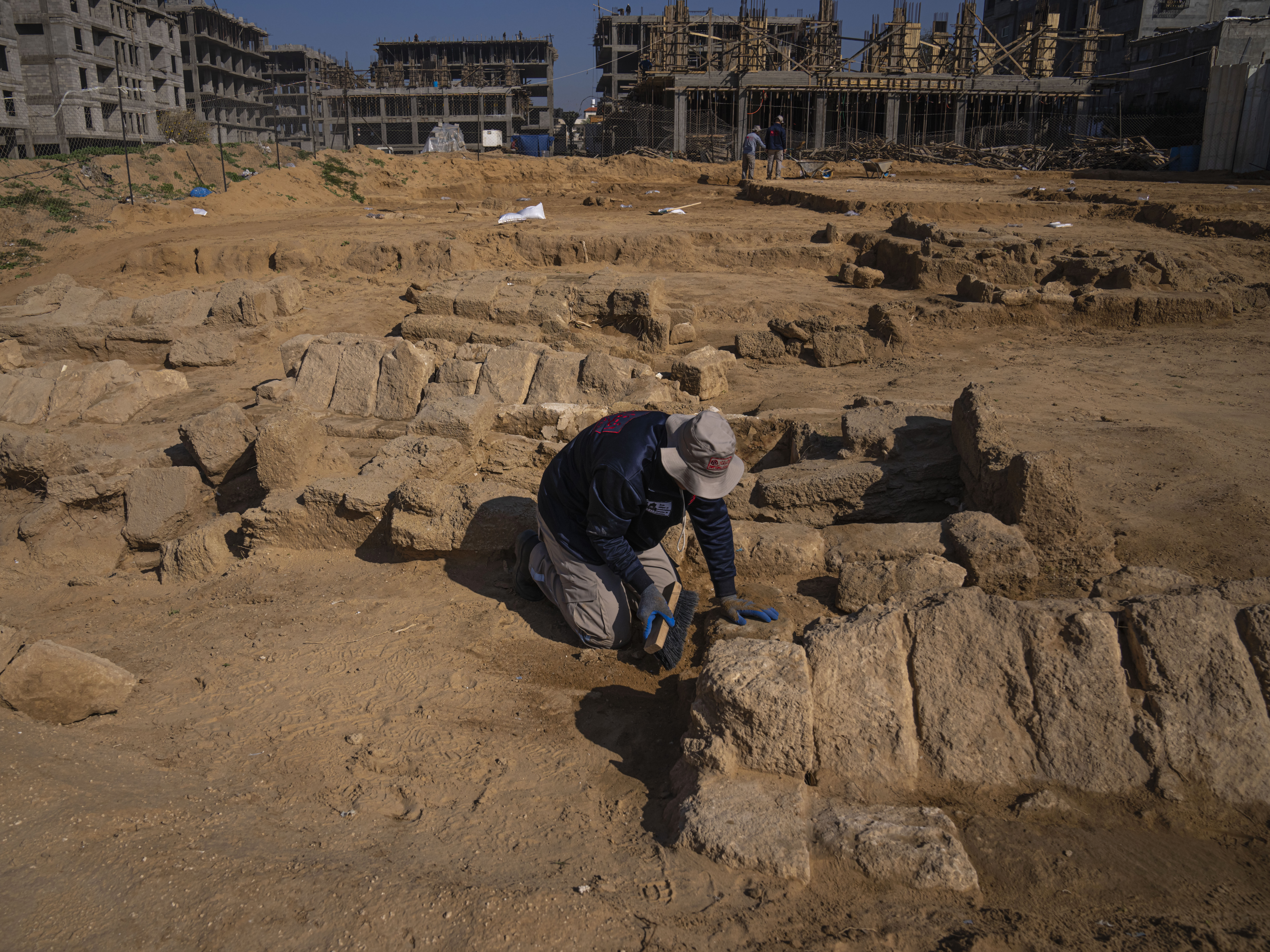 caption: A Palestinian excavation team works in a newly discovered Roman-era cemetery in the Gaza Strip on Sunday. Authorities in Gaza announced the discovery of over 60 tombs in the ancient burial site.