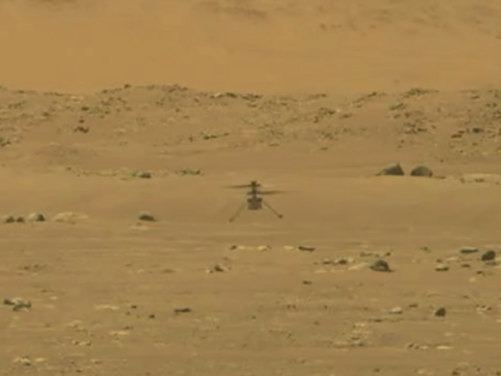 caption: In this image from NASA, the space agency's 4-pound, experimental helicopter Ingenuity lands on the surface of Mars on Monday.
