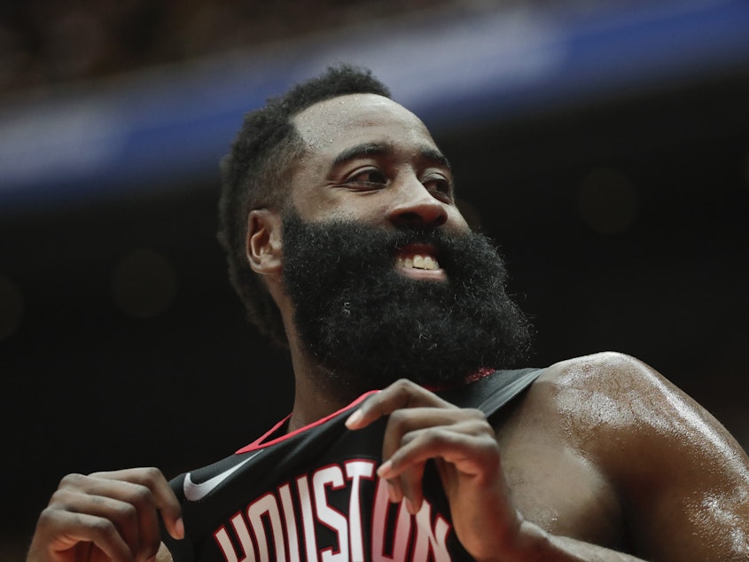 caption: Houston Rockets' James Harden smiles during the first half of an NBA preseason basketball game against the Toronto Raptors.