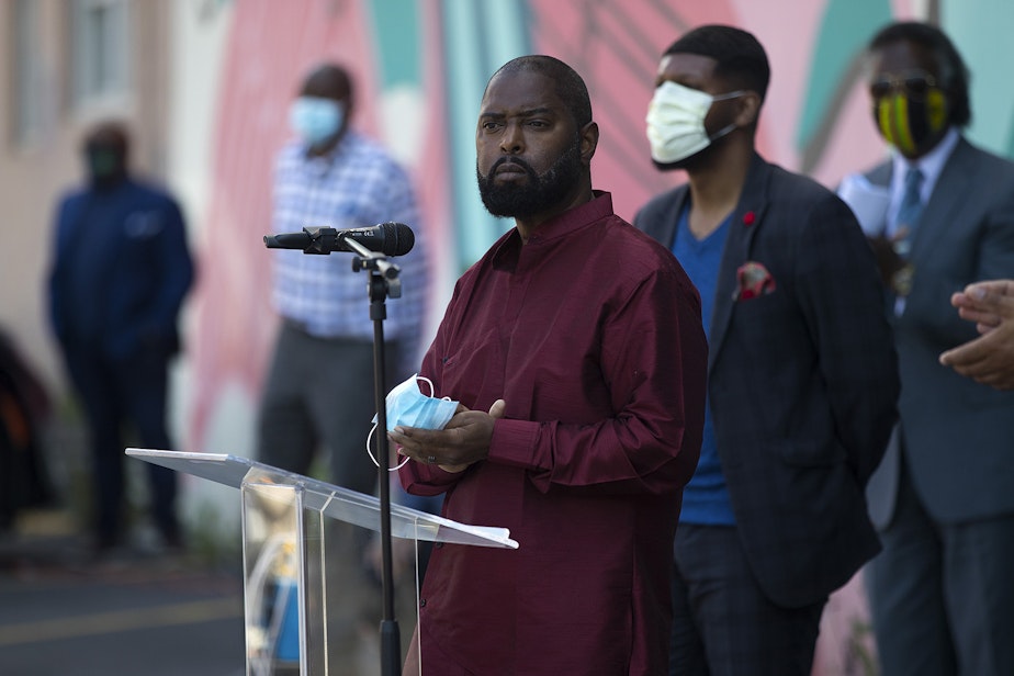 caption: Andre Taylor speaks to the crowd during a vigil to recognize the senseless killing of African American men and women outside of the First African Methodist Episcopal Church on Monday, June 1, 2020, in Seattle.