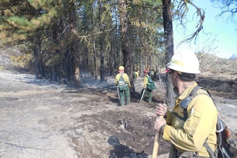 caption: Firefighters from Salem, Oregon, mop up hotspots on Judy Doran McBride's ranch near Twisp this weekend.