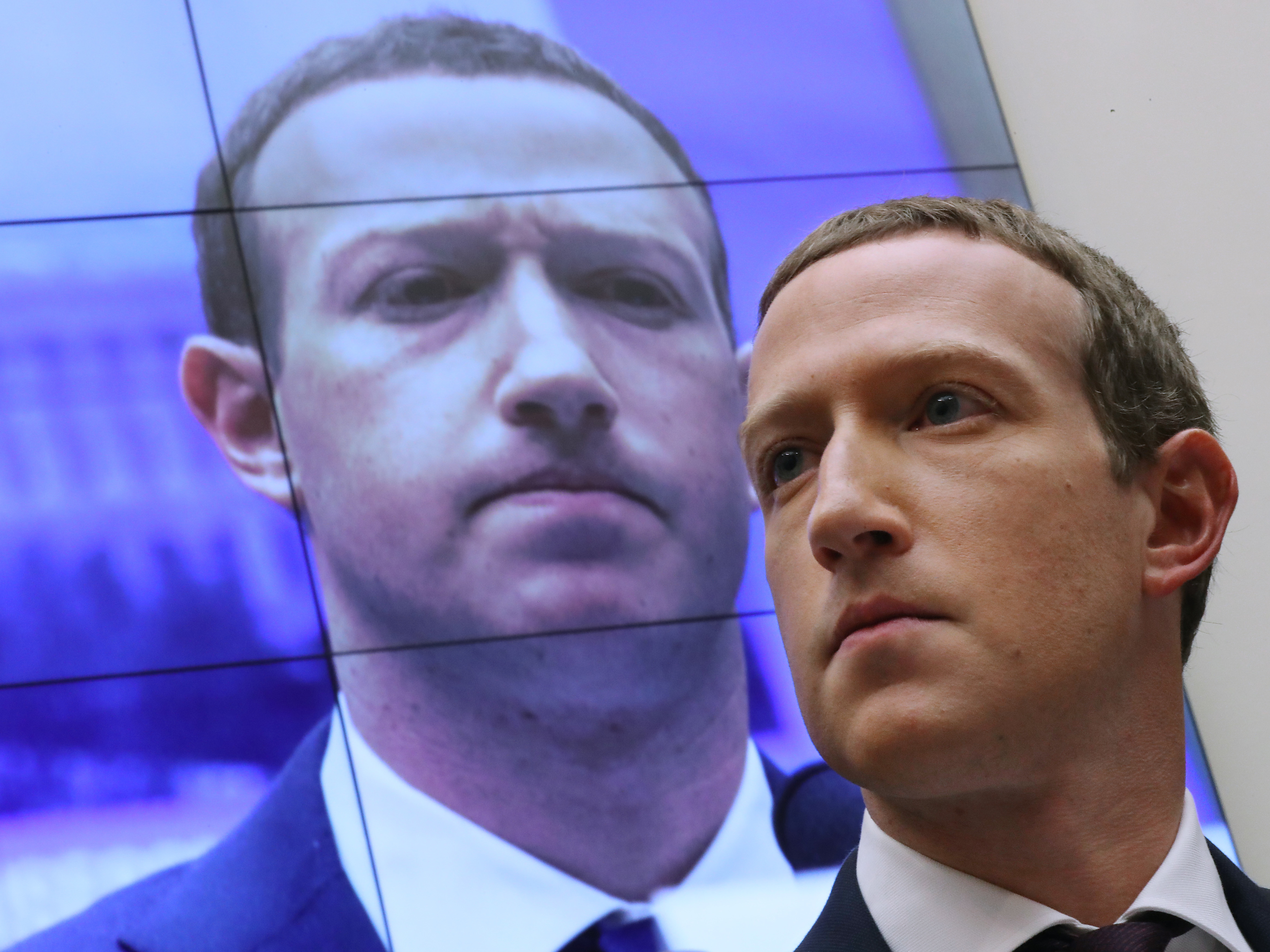 caption: Facebook CEO Mark Zuckerberg testifies before the House Financial Services Committee in 2019. His company has been hit with twin lawsuits alleging it abused its power to crush rivals.