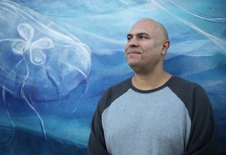 caption: Mark Mendez poses for a portrait in front of a mural painted by Esteban Camacho Steffensen on Thursday, December 6, 2018, on Northeast 127th Street in Seattle. 
