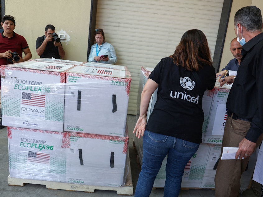 caption: Palestinian Health Ministry staff members in Nablus receive 300,000 doses of COVID vaccines donated by the United States through through the COVAX vaccine-sharing initiative on August 24, 2021.