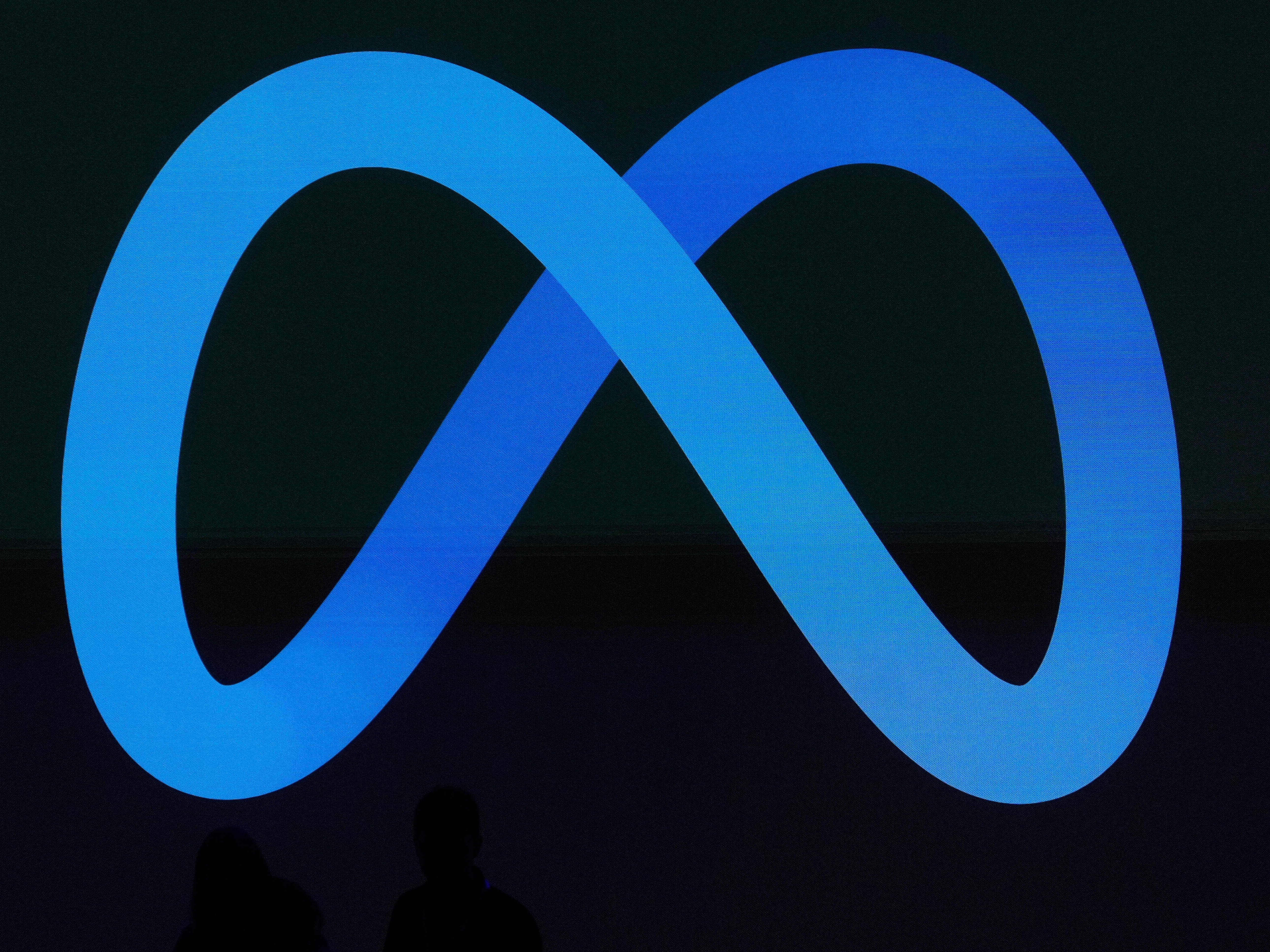 caption: A Meta logo is shown on a video screen at LlamaCon 2025, an AI developer conference, in Menlo Park, Calif., April 29, 2025.
