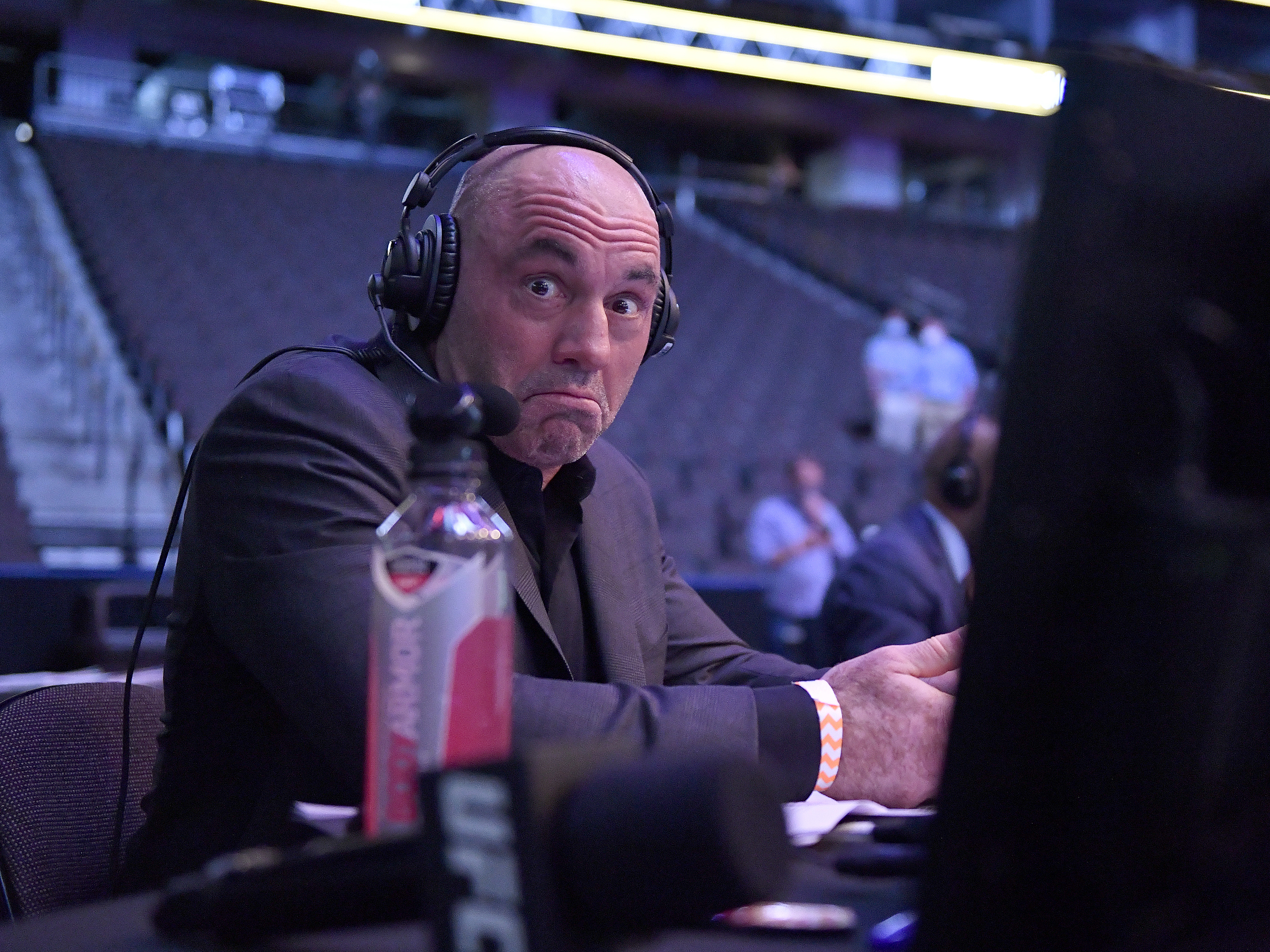 caption: Joe Rogan, the comedian, TV commentator and podcaster, reacts during an Ultimate Fighting Championship event in May 2020.