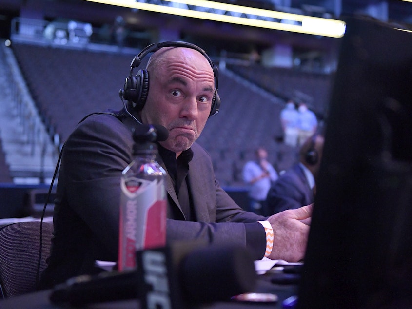caption: Joe Rogan, the comedian, TV commentator and podcaster, reacts during an Ultimate Fighting Championship event in May 2020.