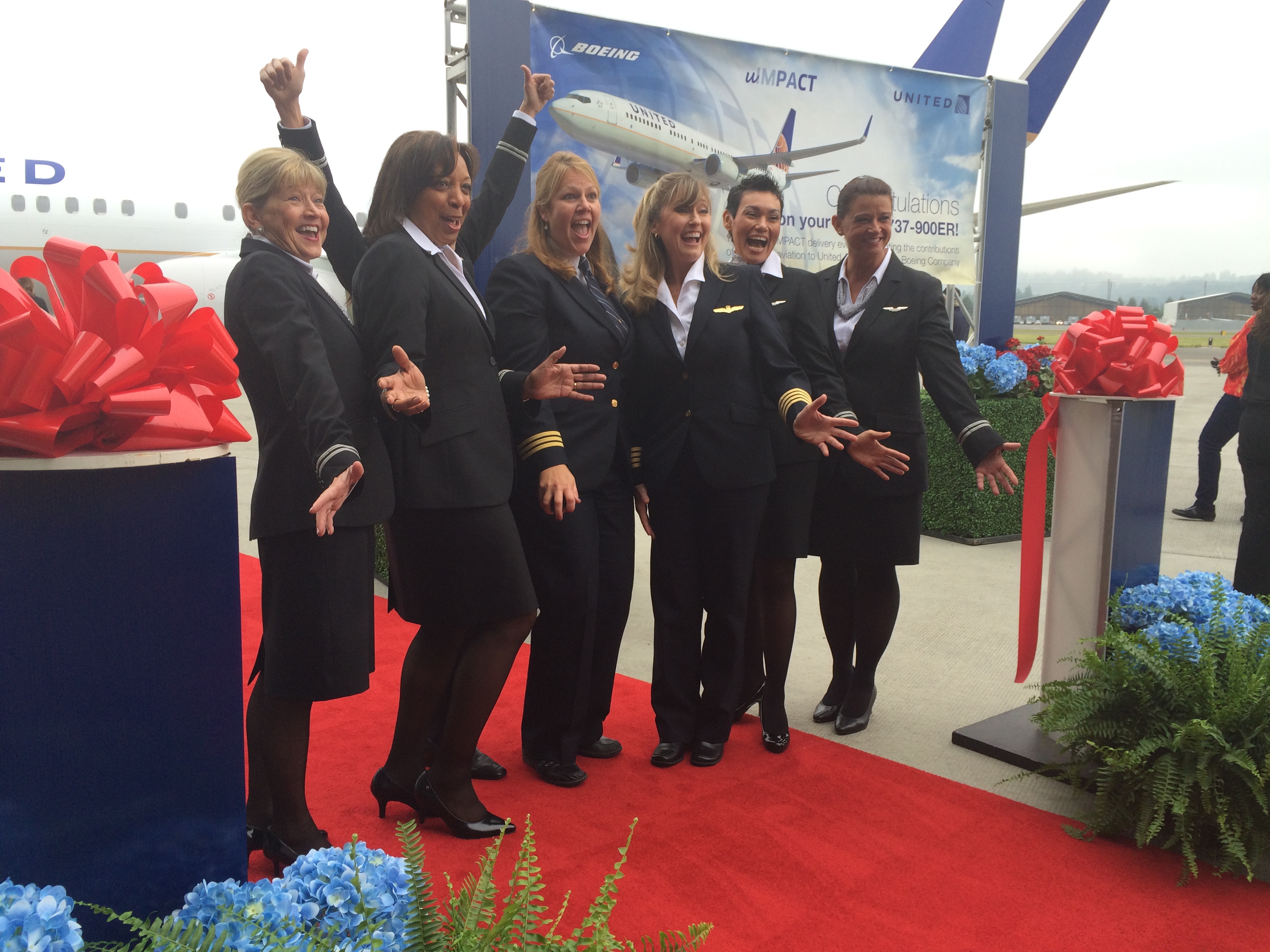 caption: An all-female United Airlines crew celebrates picking up a new Boeing 737-900. 
