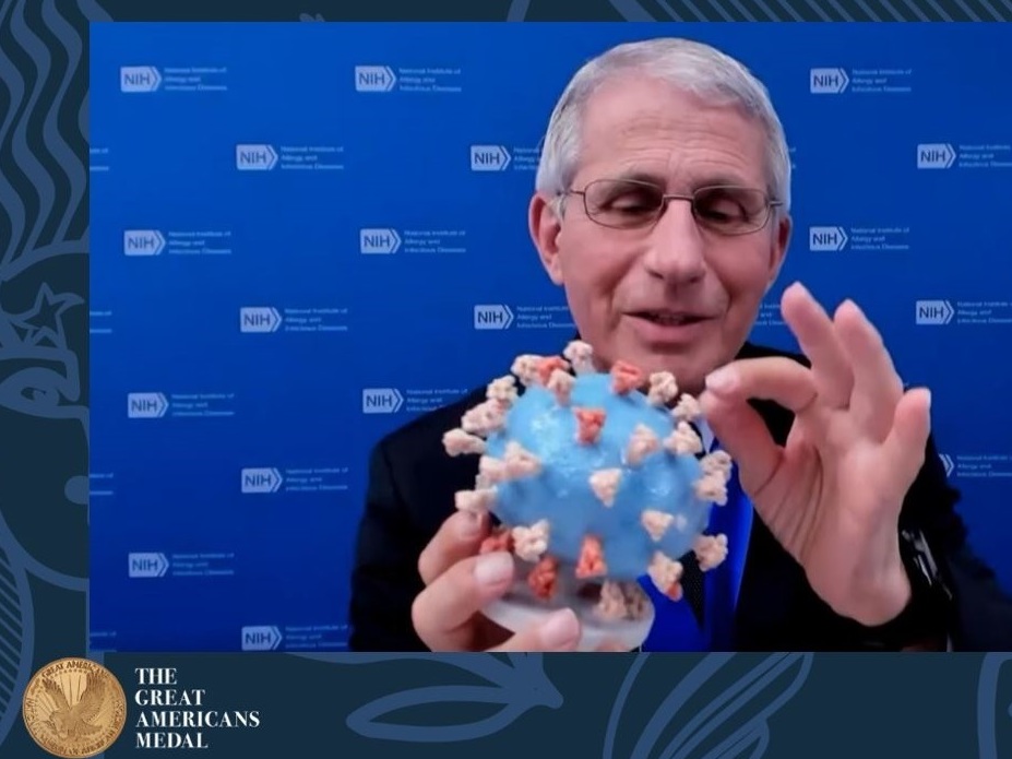 caption: Dr. Anthony Fauci holds his personal 3D-printed model of the SARS-CoV-2 virion during the "Great Americans Awards Program."