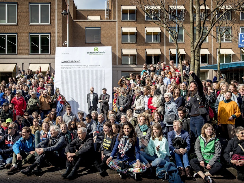 caption: Activists march to Shell's headquarters in The Hague, Netherlands, in April 2019, delivering a legal summons to the company. The civil case began Tuesday, with plaintiffs demanding the company reduce its carbon dioxide emissions.