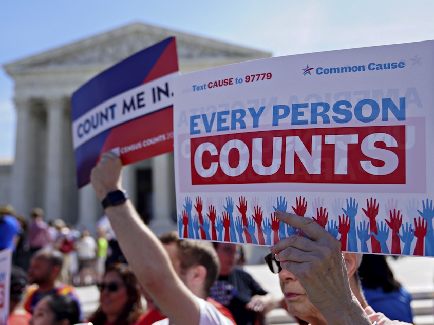 caption: Demonstrators hold signs about the 2020 census outside the U.S. Supreme Court in 2019.