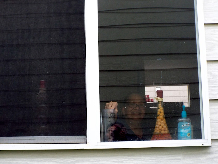 caption: My grandma Roselie Isturis smiles through our kitchen window on June 15, 2020, while washing the dishes and cleaning the counter.
