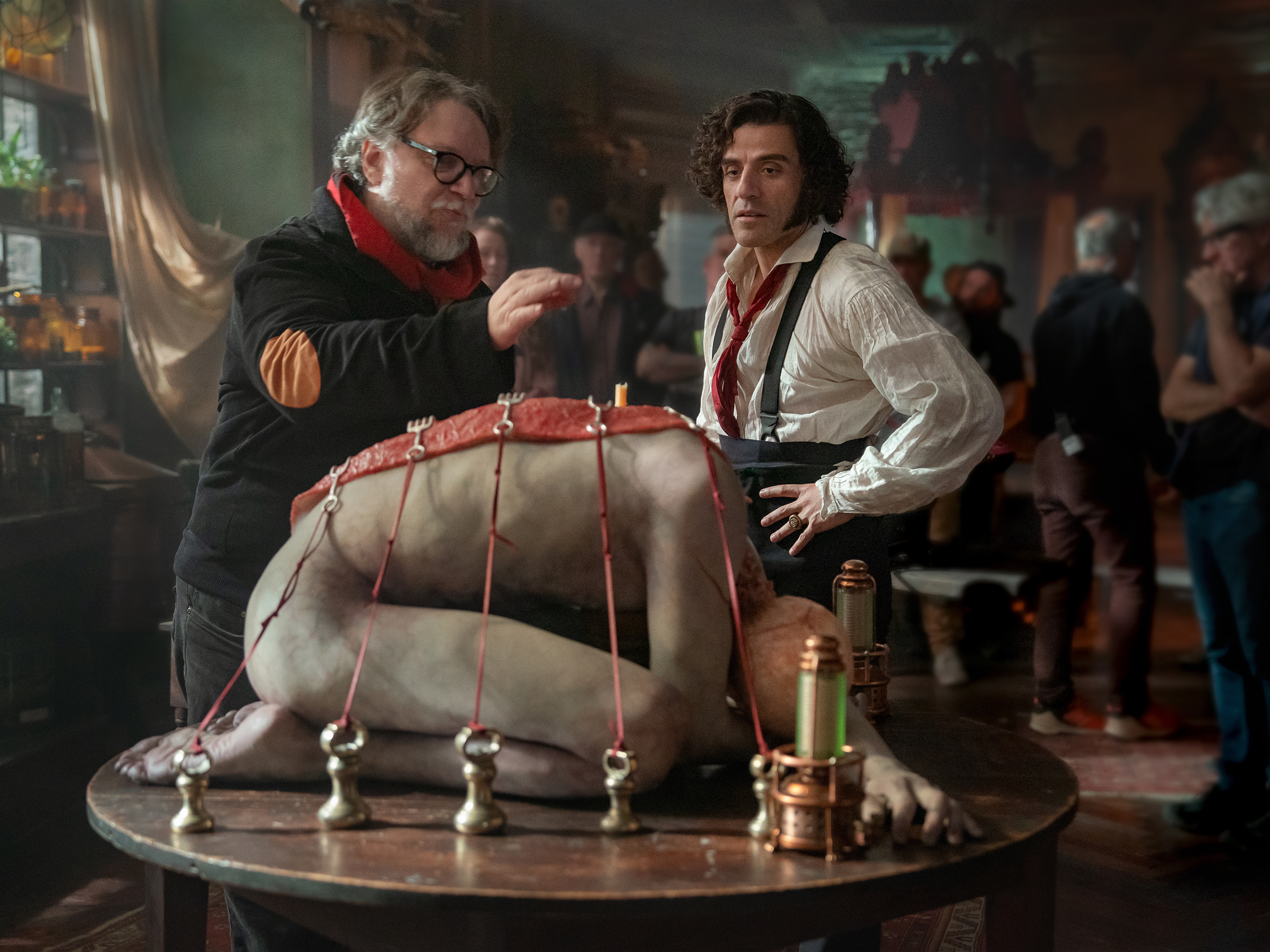caption: Director Guillermo del Toro, left, speaks with and Oscar Isaac on the set of <em>Frankenstein</em>.