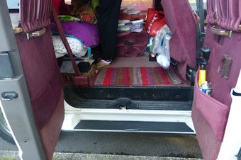 caption: The back of Elizabeth Jay's Dodge Ram minivan doubles as her living room and bedroom.