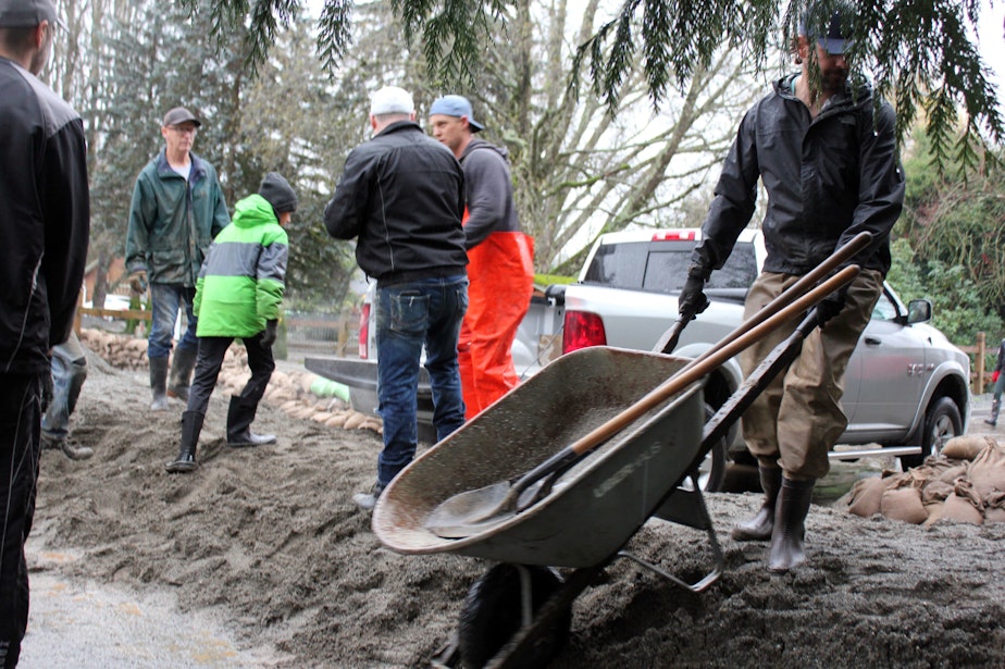 caption: Volunteers and residents create flood barriers in a low-lying neighborhood of Abbotsford, British Columbia, on Nov. 28.
