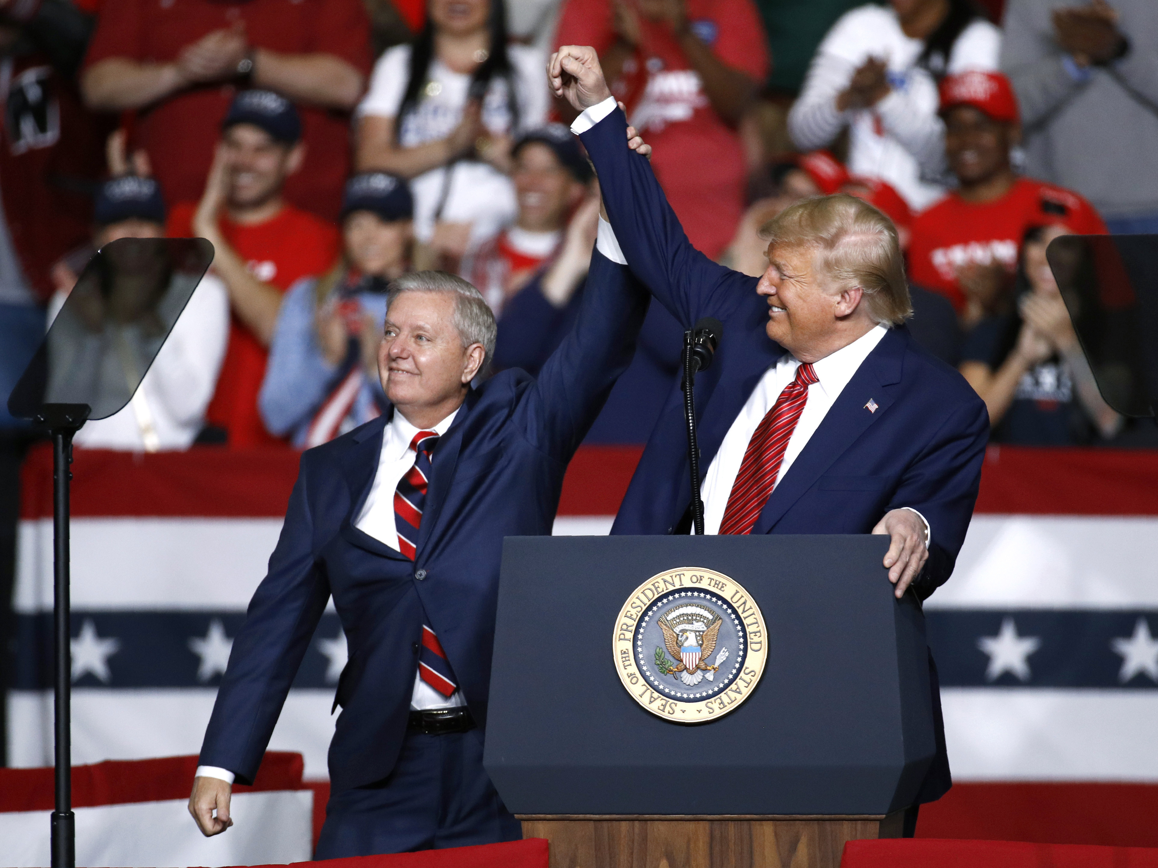 caption: Sen. Lindsey Graham, R-S.C., stands onstage with President Trump during a Feb. 28 campaign rally in North Charleston, S.C. His allegiance to Trump has left some moderate voters feeling snubbed and switching allegiances to Democrat Jaime Harrison.