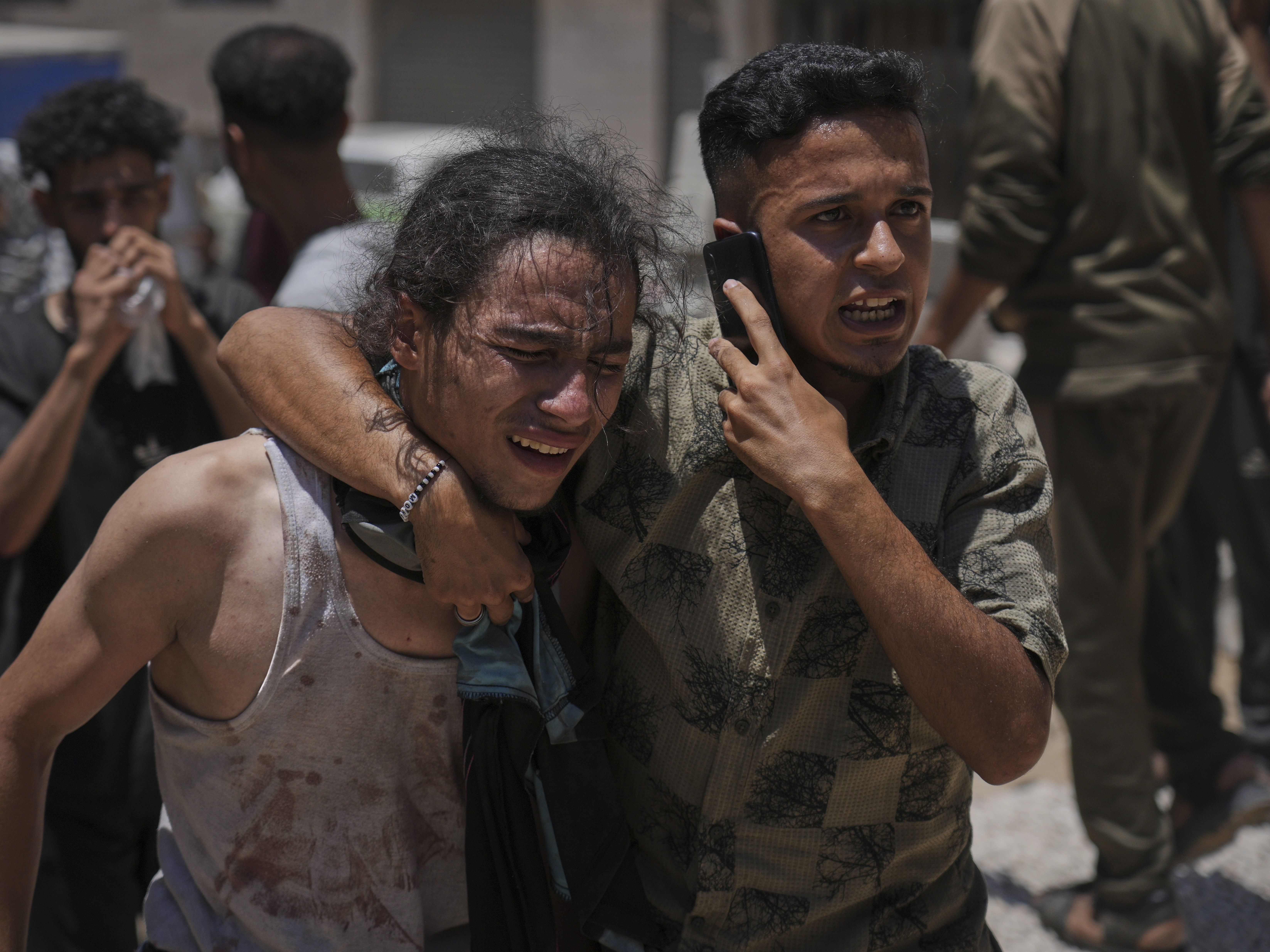 caption: Palestinians react after carrying the bodies of those killed while trying to reach aid trucks entering northern Gaza through the Zikim crossing with Israel, at Shifa Hospital in Gaza City, on Sunday.