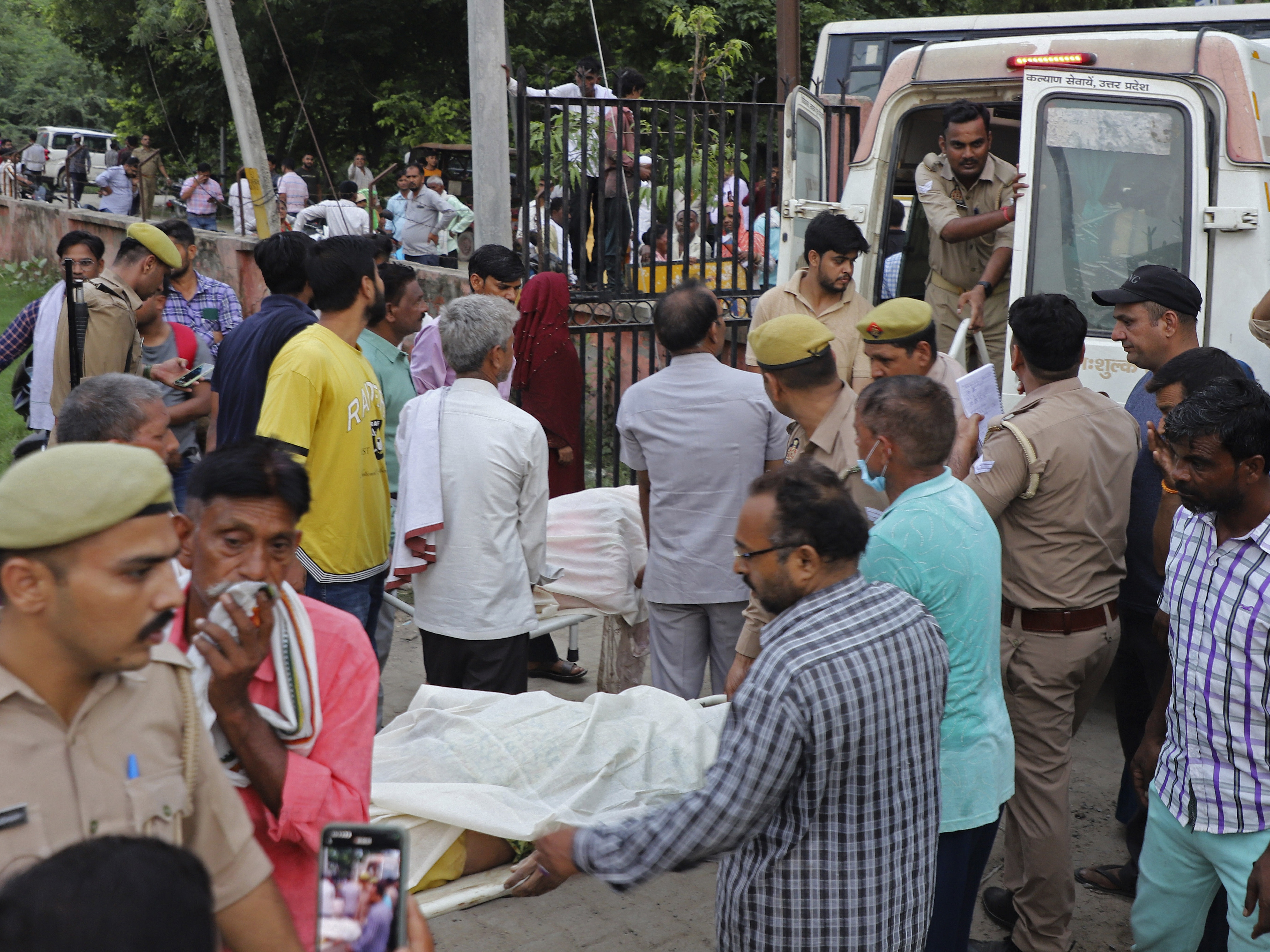 caption: Relatives and volunteers carry bodies on stretchers at the Sikandrarao hospital in Hathras district in northern India on Tuesday. A stampede among thousands of people at a religious gathering killed more than 120 and left scores injured, officials said.<br>