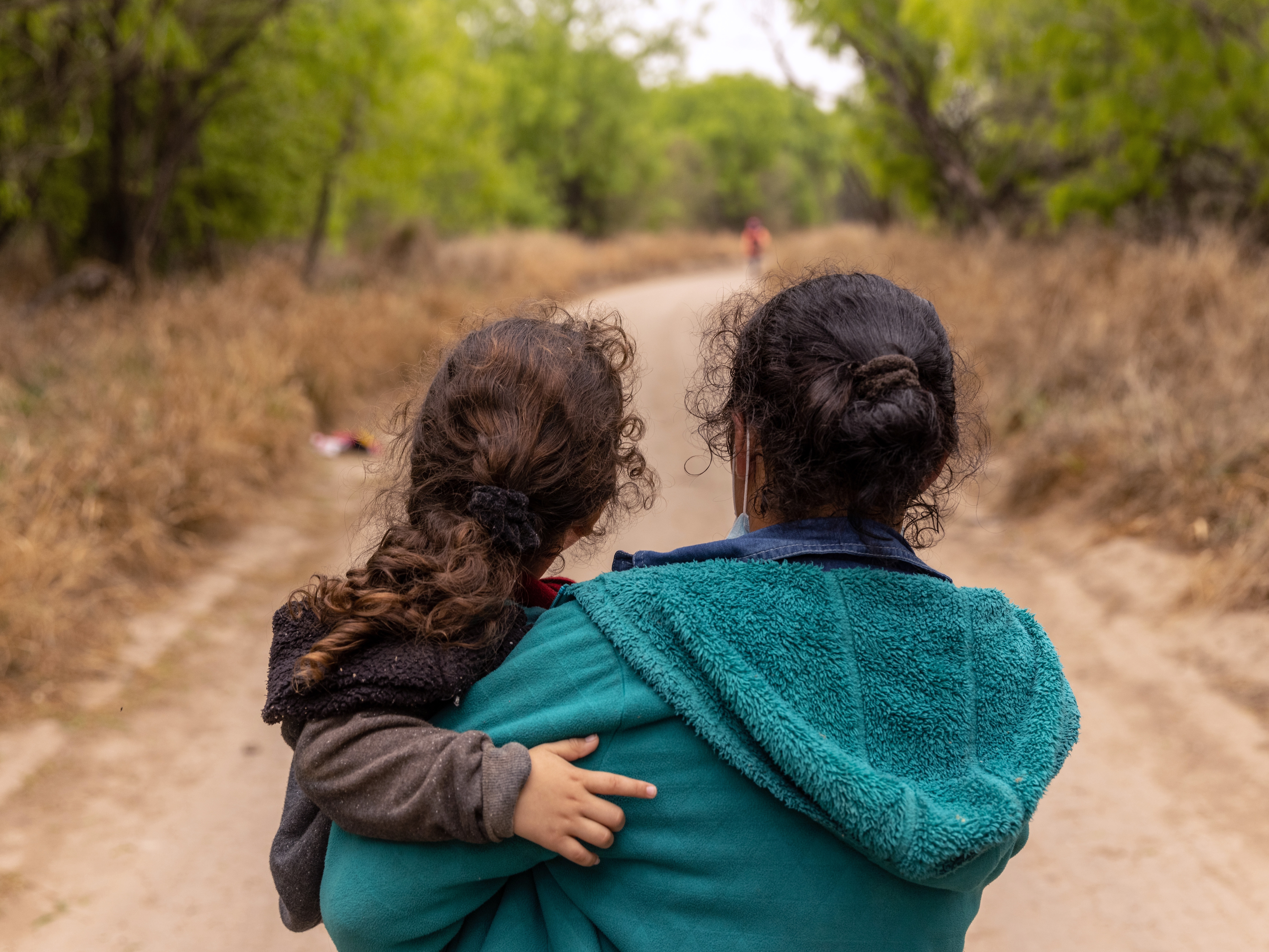 caption: Asylum-seekers from Honduras walk toward a U.S. Border Patrol checkpoint after crossing the Rio Grande from Mexico in 2021 near Mission, Texas.