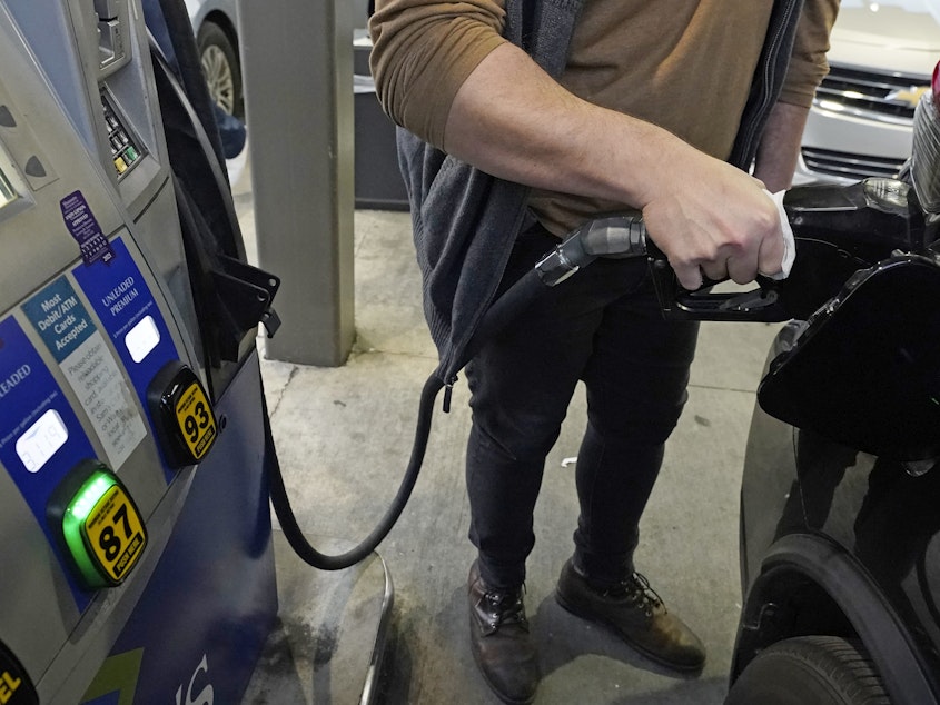 caption: A customer pumps gasoline into his car in Gulfport, Miss., on Feb. 19.