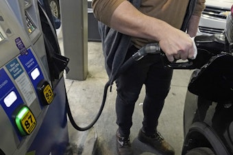 caption: A customer pumps gasoline into his car in Gulfport, Miss., on Feb. 19.