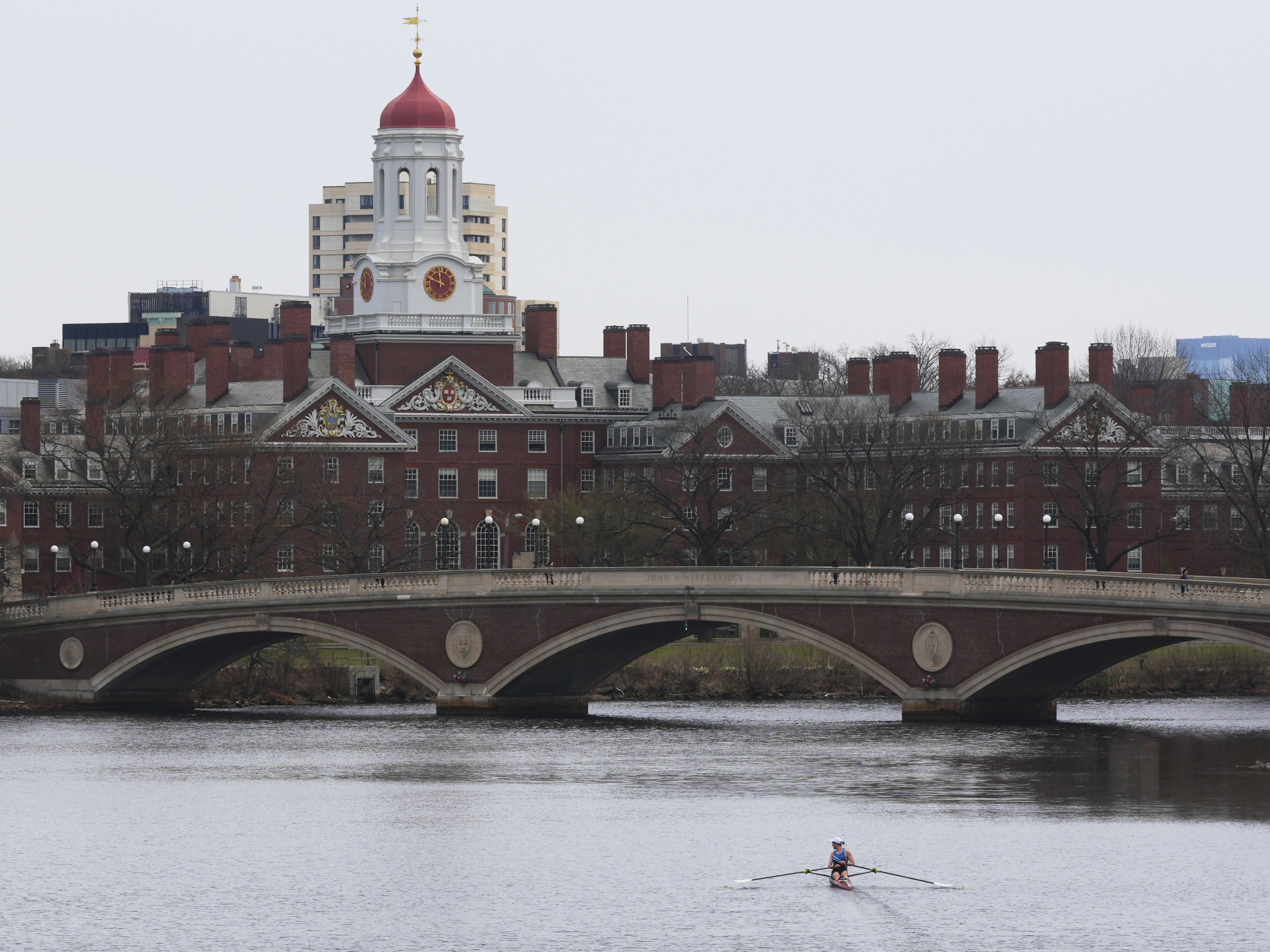 caption: A sculler rows down the Charles River near Harvard University, at rear, on April 15, 2025, in Cambridge, Mass.