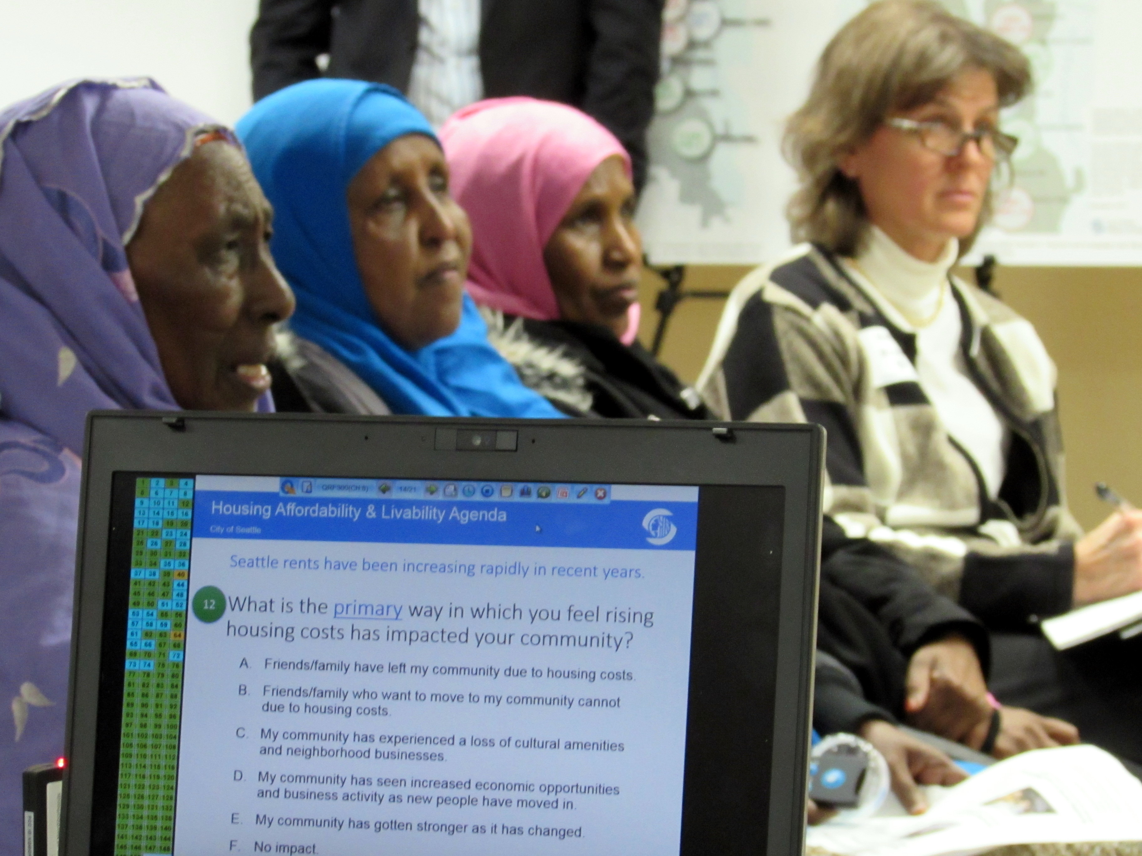 caption: Audience members take an electronic survey at an open house on affordable housing at an Ethiopian community center in south Seattle.