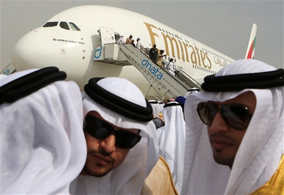 caption: Emirati officials greet each other on Sunday in front of an Emirates Airbus A380 on display during the opening day of the Dubai Airshow in Dubai.