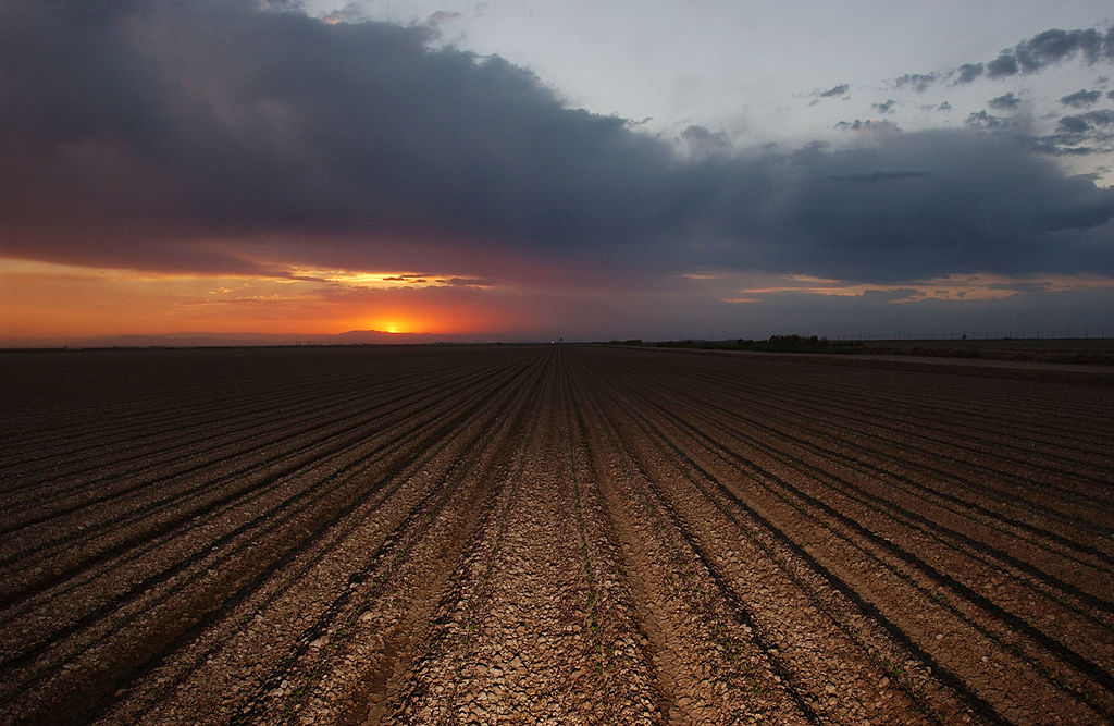 caption: The sun sets on a plowed field that will need Colorado River water to yield a crop October 17, 2002 near El Centro, California. (David McNew/Getty Images)