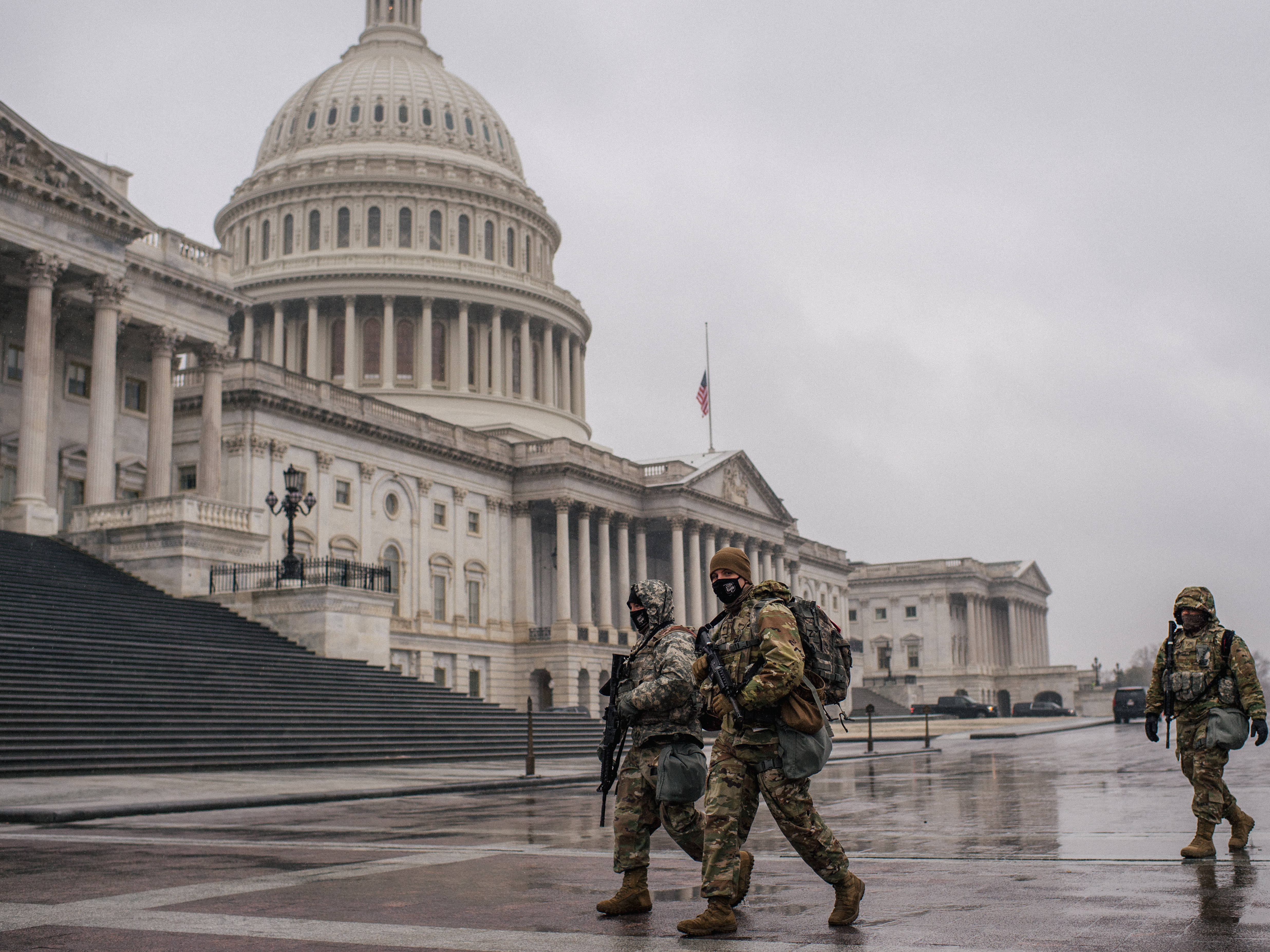 caption: National Guard members walk through the U.S. Capitol grounds following the conclusion of the second impeachment trial of former President Donald Trump on Feb. 13.