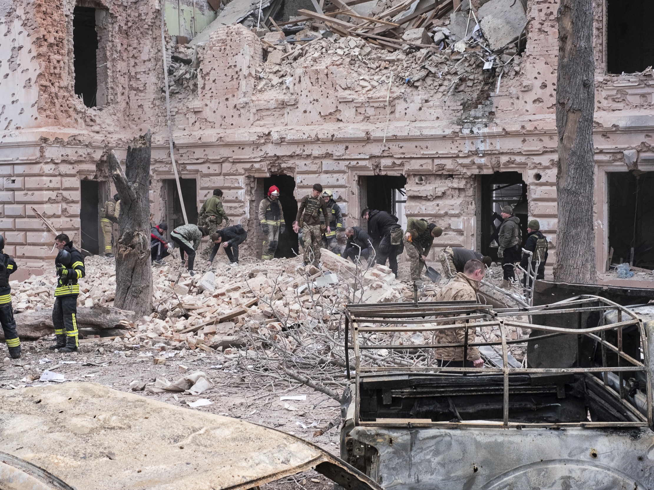 caption: Rescue workers clear the rubble of a building hit by a Russian missile strike on Sumy, Ukraine on April 13.