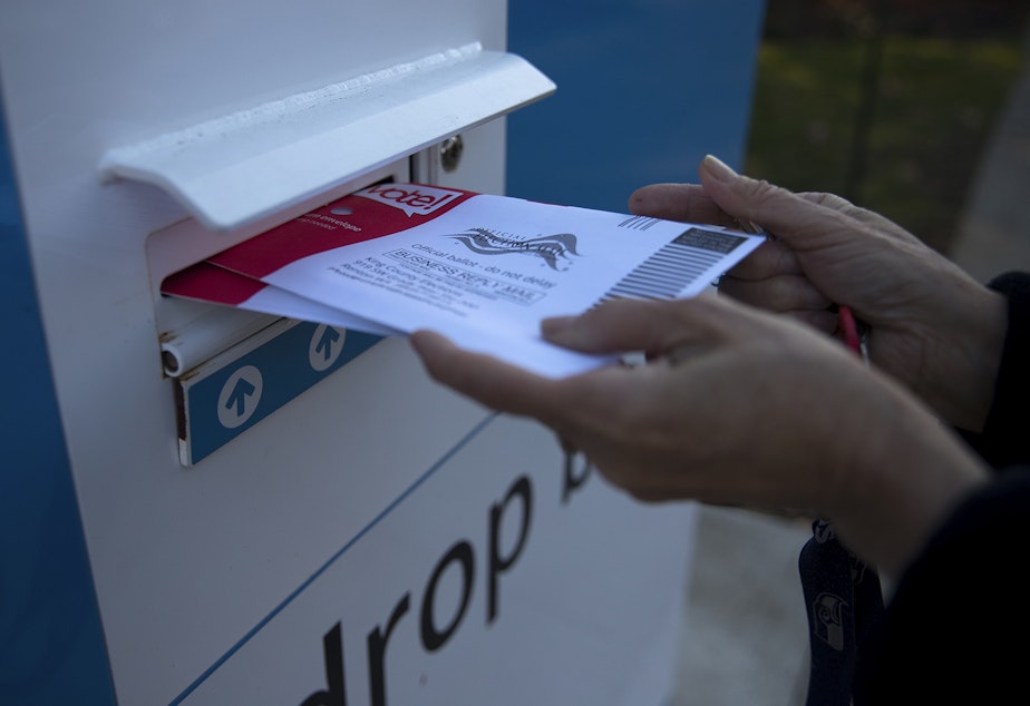 caption: A voter drops off ballots on Tuesday, November 5, 2019, at the NewHolly Neighborhood Campus on 32nd Avenue South in Seattle.