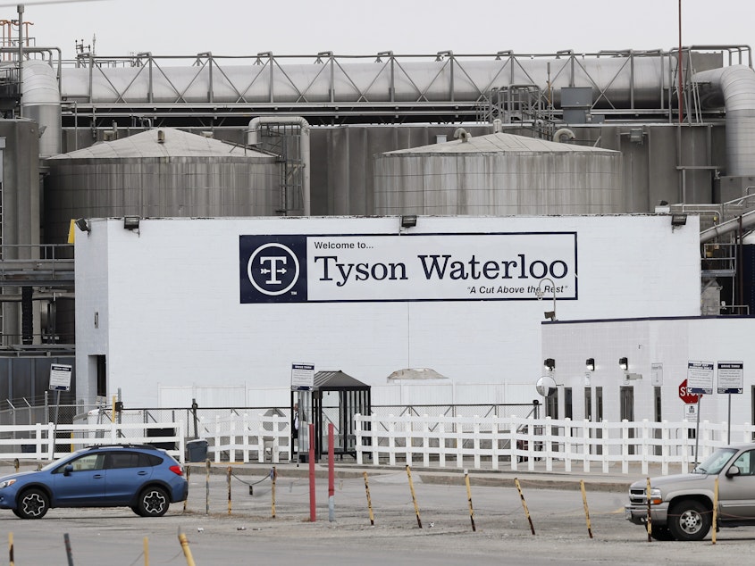 caption: Vehicles sit in a near empty parking lot outside the Tyson Foods plant in Waterloo, Iowa, on May 1.