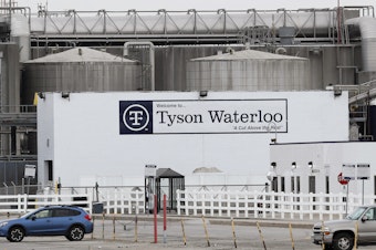 caption: Vehicles sit in a near empty parking lot outside the Tyson Foods plant in Waterloo, Iowa, on May 1.