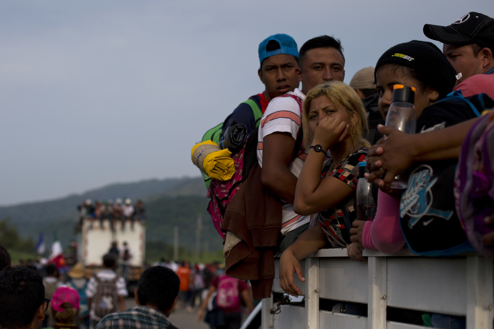 caption: Migrants hitch rides on passing truck as they continue on their journey after Mexican police briefly blockaded the road to keep them from advancing, outside the town of Arriaga, Mexico, Saturday, Oct. 27, 2018. Hundreds of Mexican federal officers carrying plastic shields briefly blocked the caravan of Central American migrants from continuing toward the United States, after several thousand of the migrants turned down the chance to apply for refugee status and obtain a Mexican offer of benefits. (AP Photo/