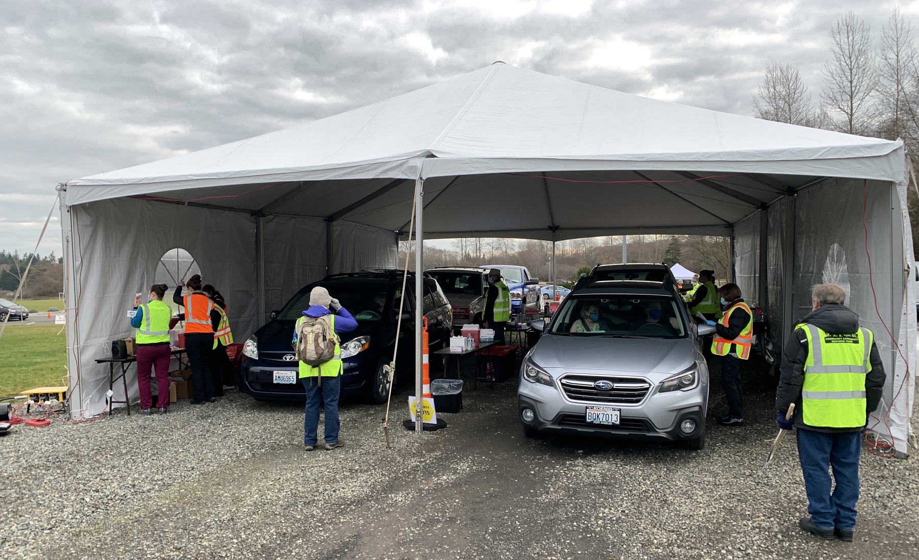 caption: After an hours-long wait, drivers pull up under a vaccination tent to get their first dose of the Moderna COVID vaccine.