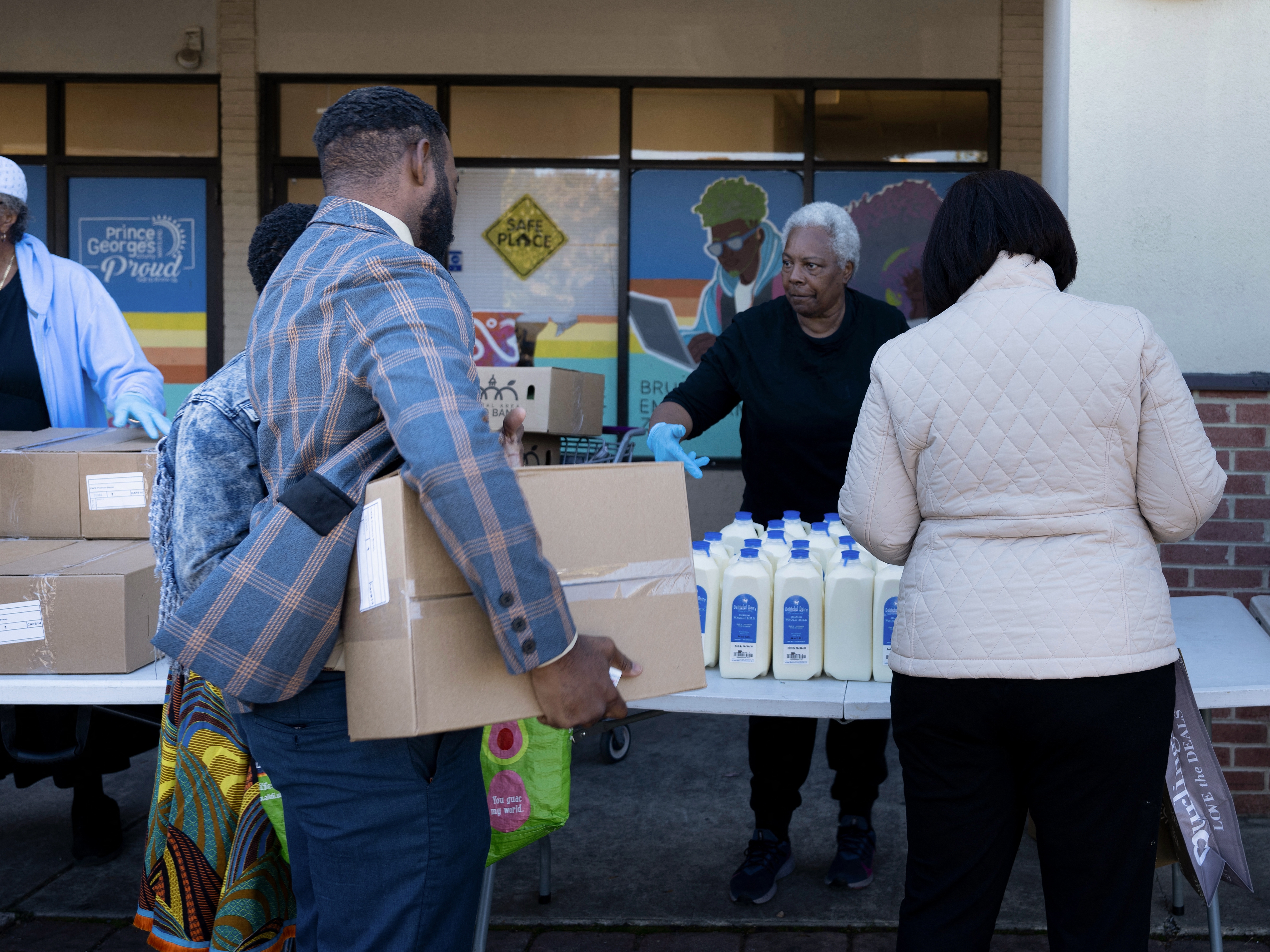 caption: People receive food for furloughed federal workers at No Limits Outreach Ministries on Oct. 21, 2025 in Hyattsville, Md. The U.S. government shutdown dragged into a third week, with Congress gridlocked in a clash over spending and no resolution in sight to a crisis that has already cost thousands of jobs.